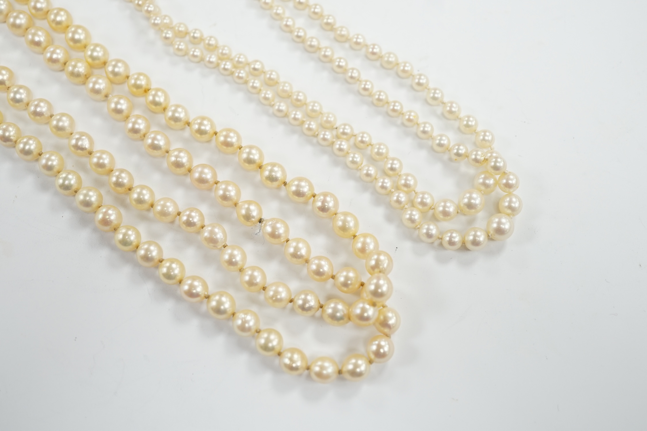 A single strand cultured pearl necklace, with turquoise? and seed pearl set 9ct clasp, 56cm and a double strand cultured pearl necklace with paste set clasp.